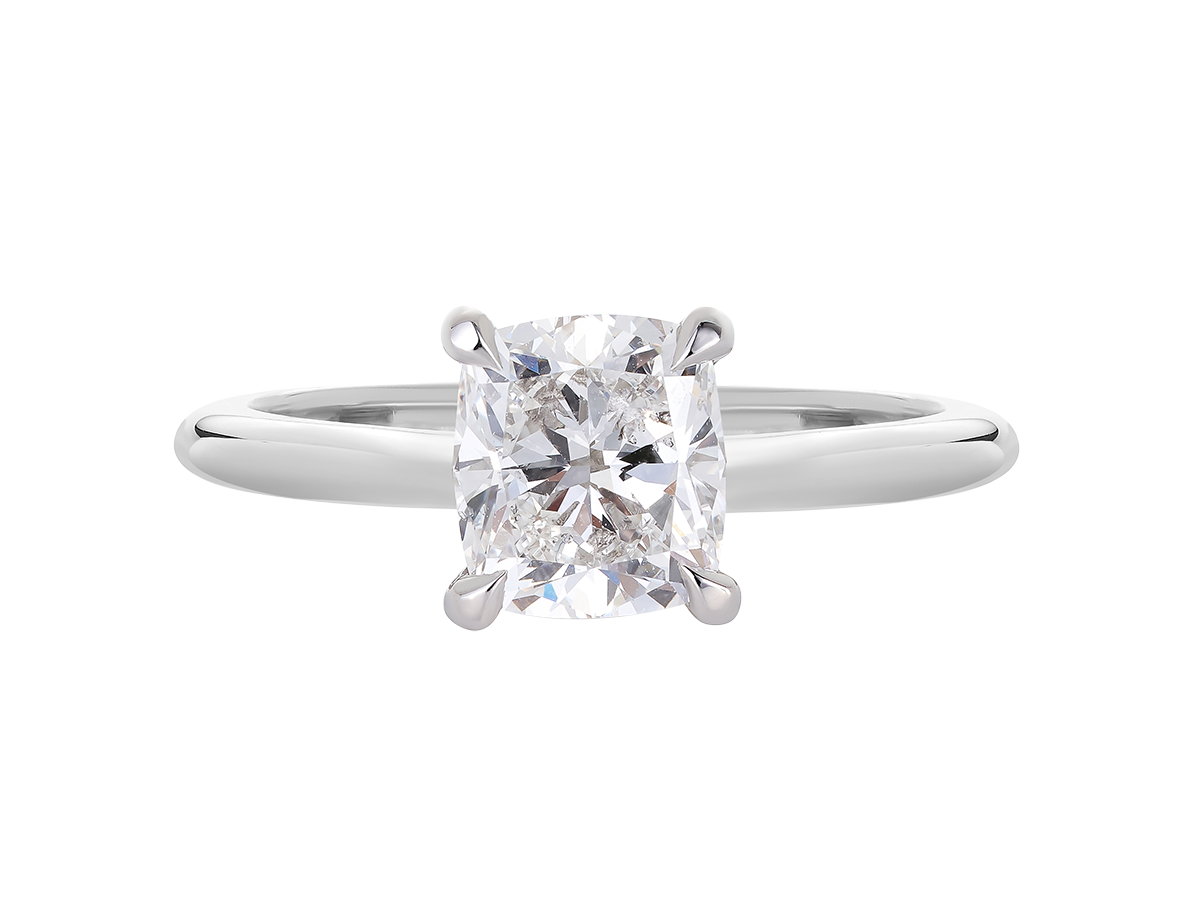 A.G cushion cut solitaire with a round profile band.