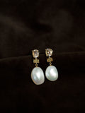 A.G Designer Jeweller custom designed trio drop earrings featuring morganite, cognac diamond, and Keshi pearls in yellow gold laid on brown velvet sheet.