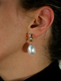 Close up of ear wearing A.G Designer Jeweller Trio Drop Earrings in yellow gold.