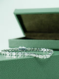 A.G Designer Jeweller custom made alternating round brilliant cut and emerald cut diamond tennis bracelet sitting on green jewellery box.