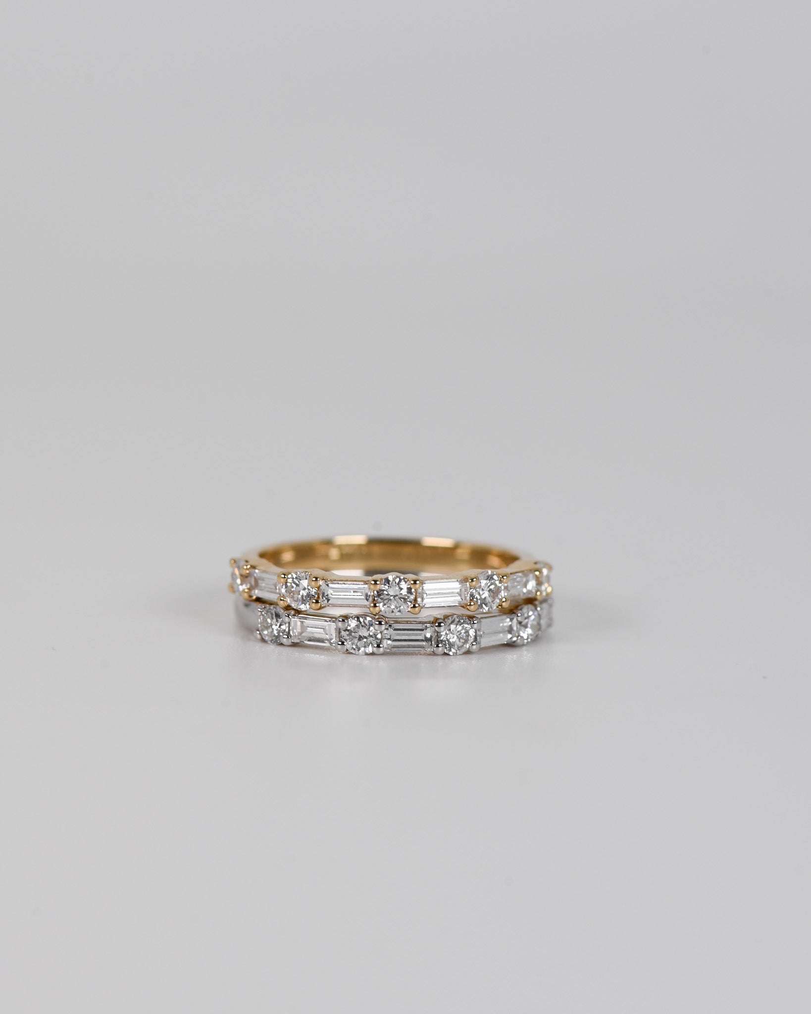 Gold and silver A.G alternating diamond wedding bands stacked on each other.