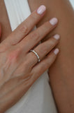 Hand with A.G alternating diamond wedding band on finger.