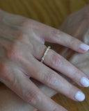 Close up of hand with A.G alternating diamond wedding band in gold on finger