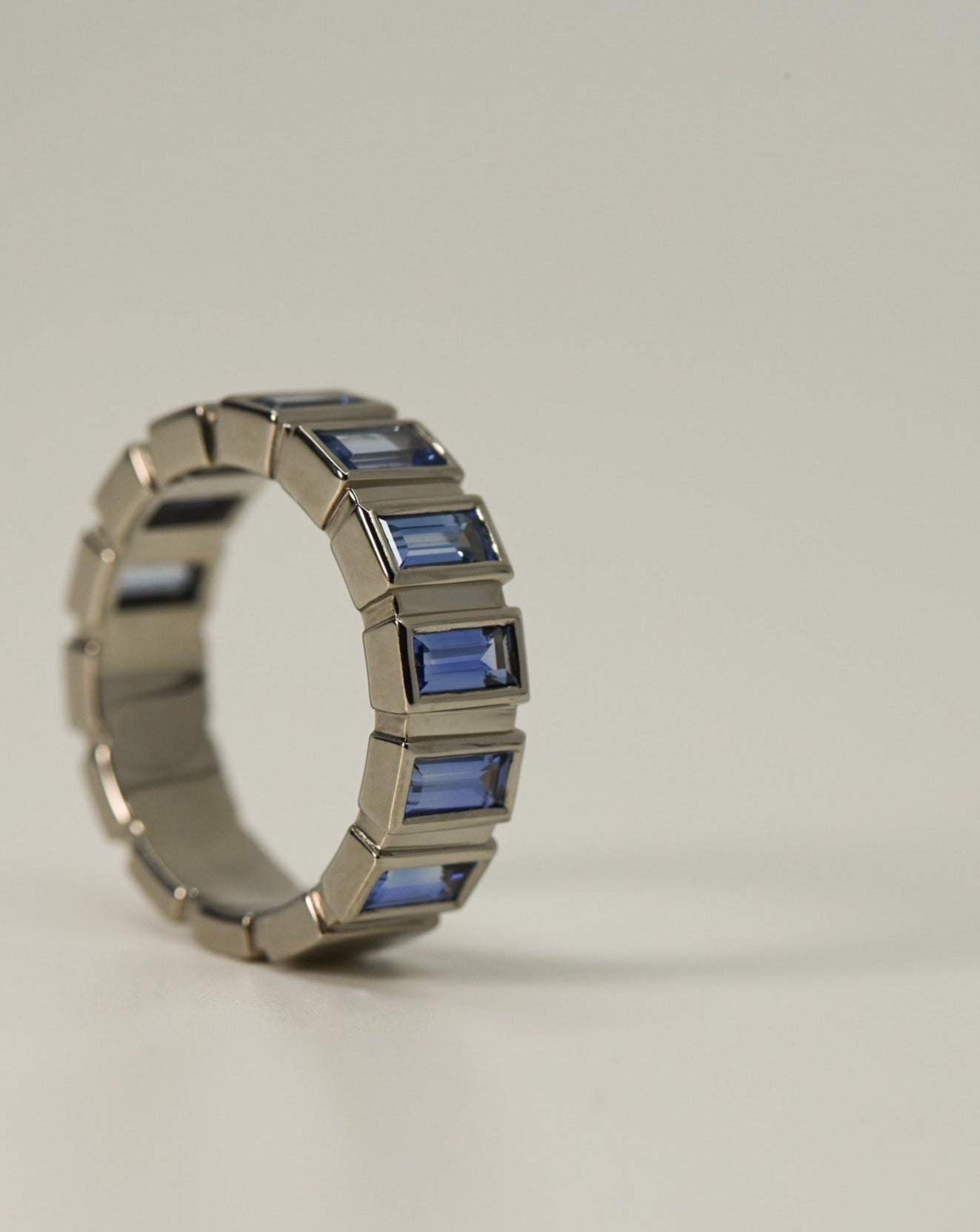 A.G Designer Jeweller custom made blue sapphire bezel set ring on side.