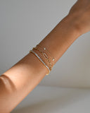 Close up of wrist wearing three A.G Designer Jeweller custom made yellow gold bracelets.