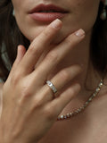 Close up of woman's hand with A.G Designer Jeweller custom made emerald cut diamond bezel set eternity band in white gold on ring finger.