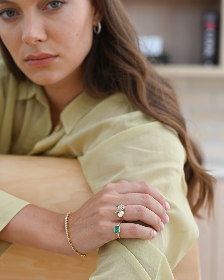 Woman in green top with A.G 1.79ct oval cut Zambian emerald ring on her finger. 
