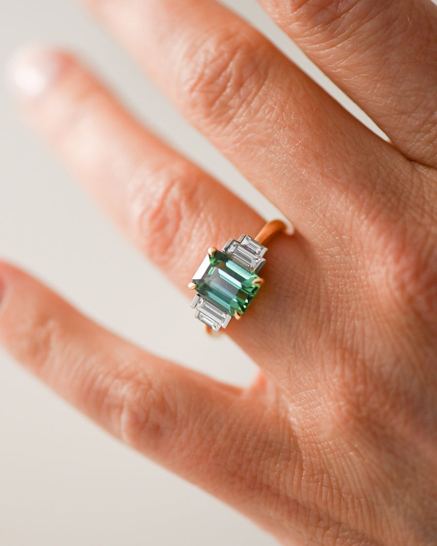 Close up of A.G tourmaline and diamond step style ring on finger. 