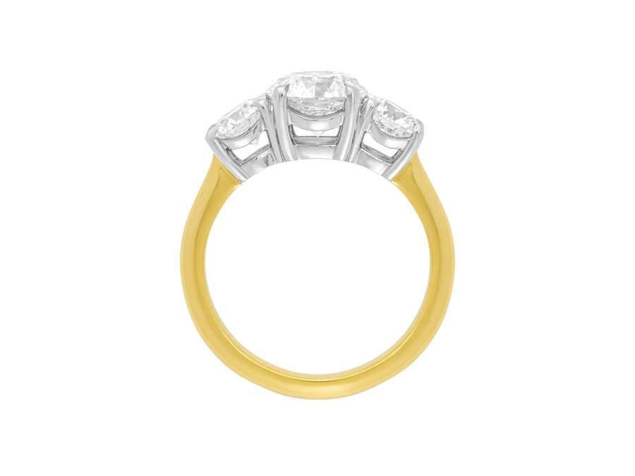 Side view of A.G round brilliant cut diamond trilogy four claw setting and half round gold band.