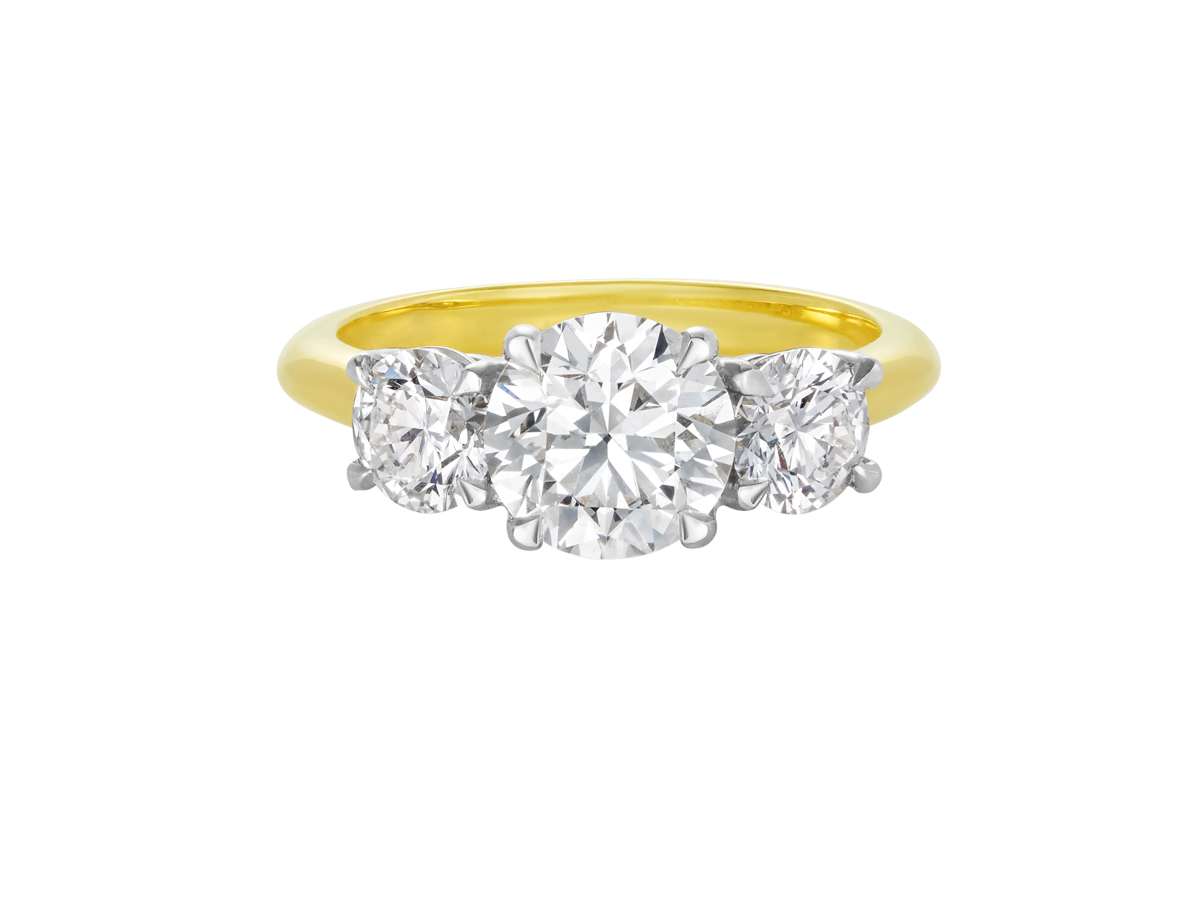 A.G round brilliant cut diamond trilogy four claw setting and half round gold band.