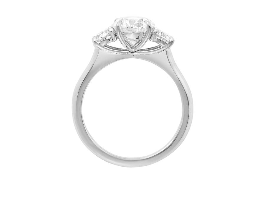 Side view of A.G round brilliant cut diamond trilogy four claw setting and half round band.